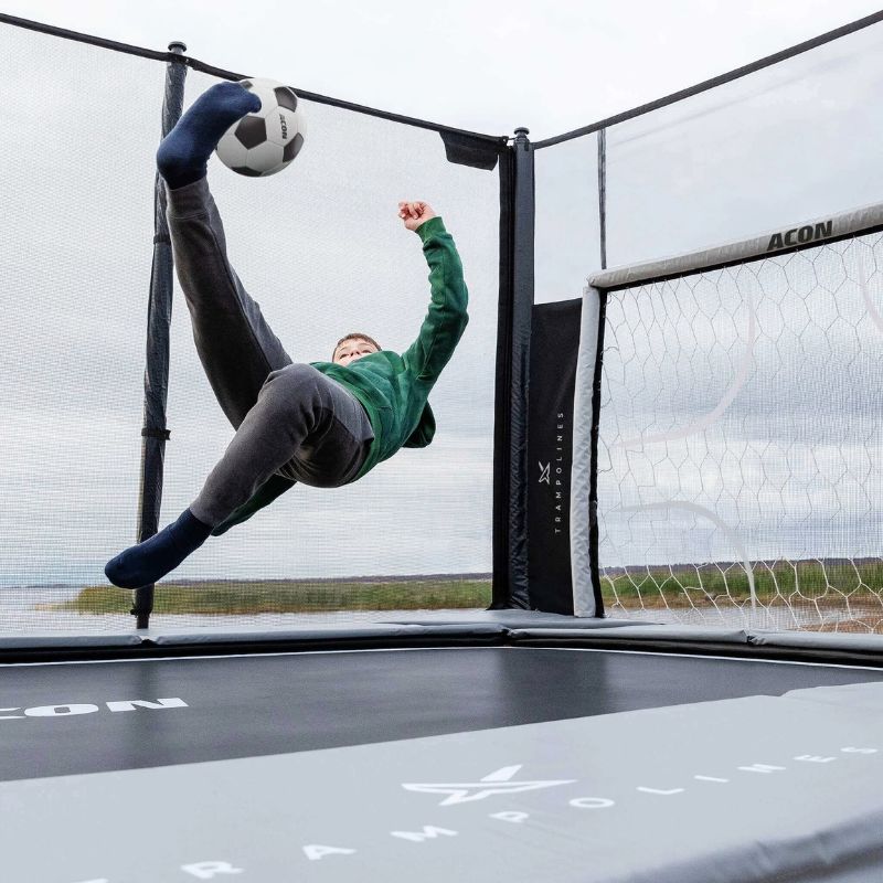 Kid playing soccer on a trampoline with ACON X Football Goal Panel 