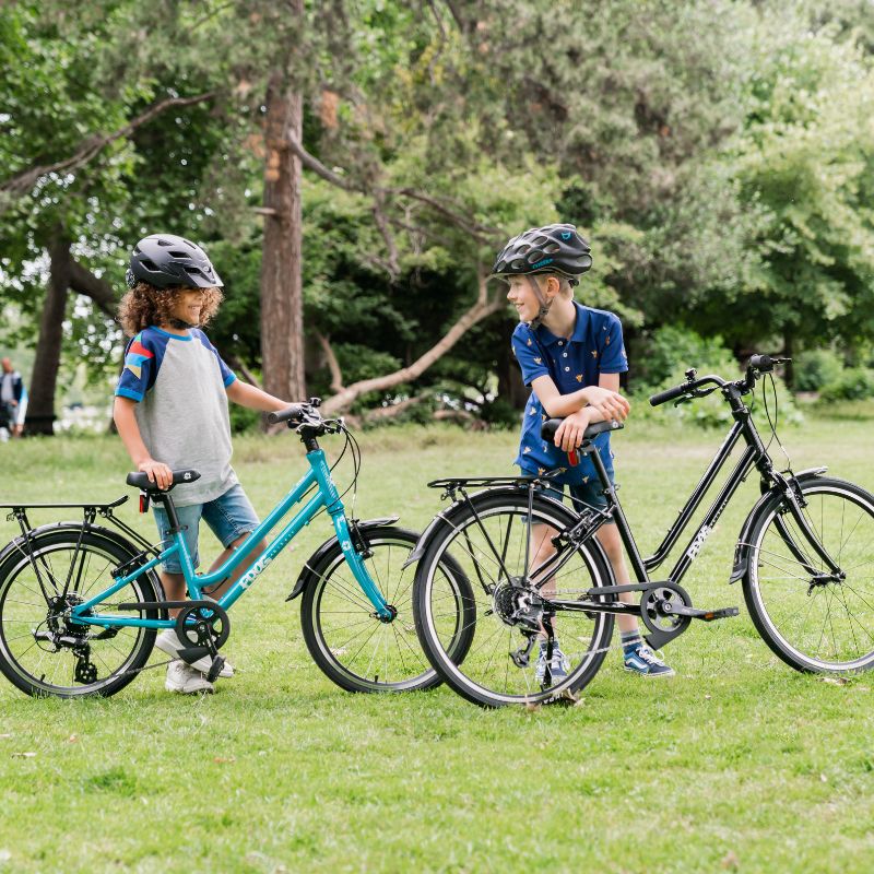 Two children with City 61 bicycles in a park setting