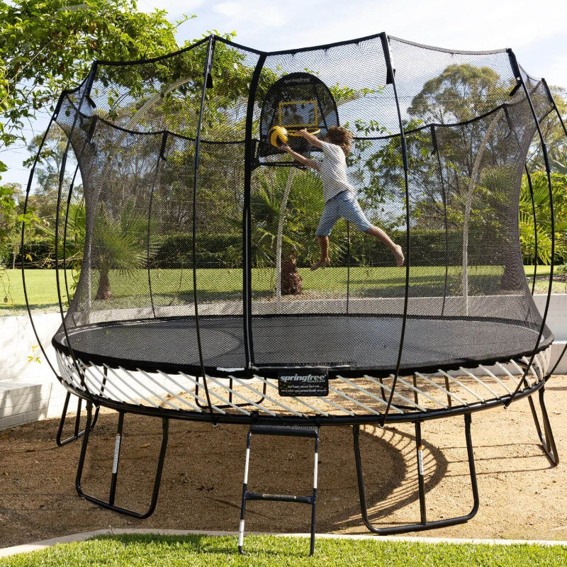 Springfree® 13ft Jumbo Round Trampoline with Kid jumping and playing basketball